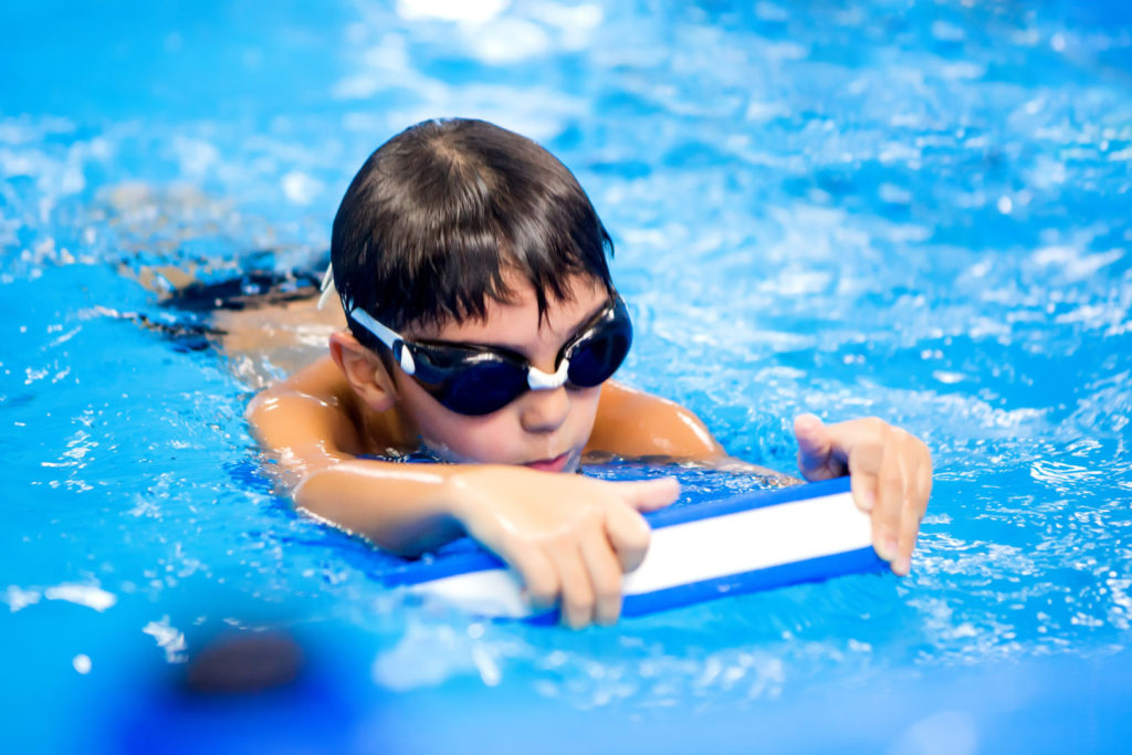 plávajúci chlapec v bazéne a výhody plávania