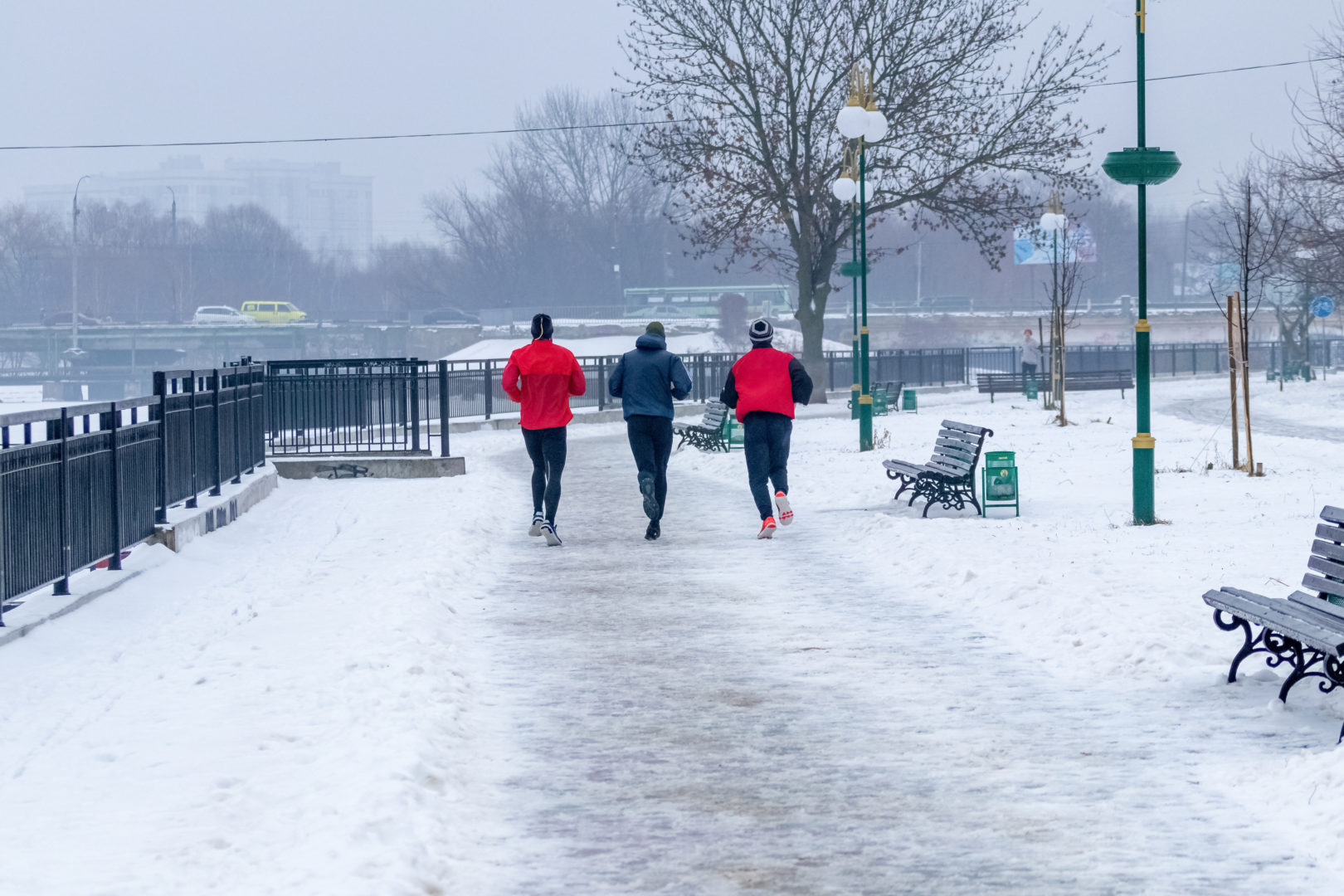 traja muži bežia v zime