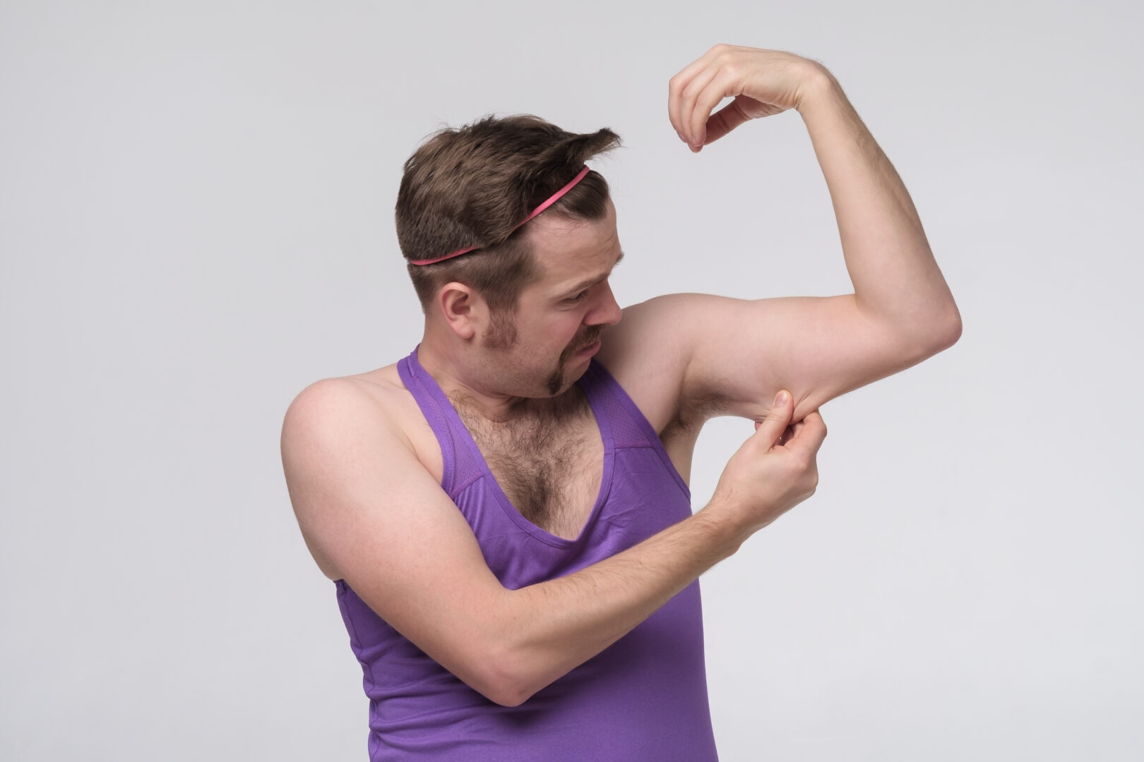 Muž skúmajúci svoj ochabnutý biceps